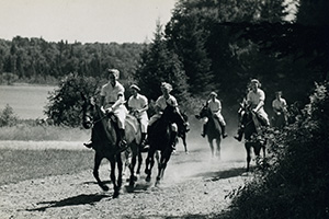Black and white photo of a group of people on horseback