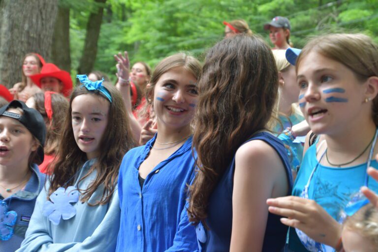 A row of girls at summer camp, with their faces painted