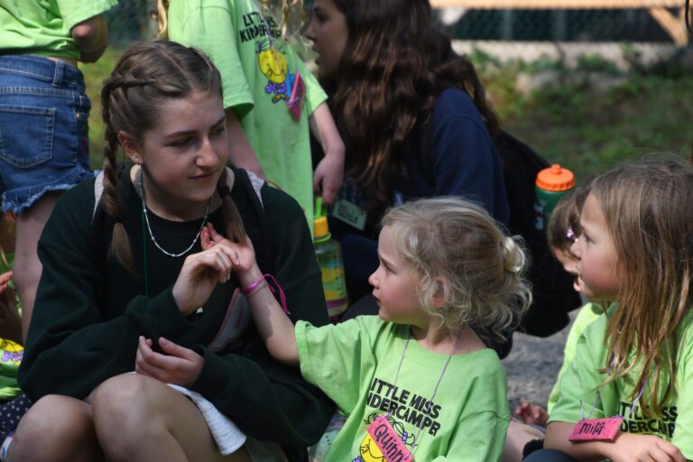 A camp counsellor holds a young campers hang