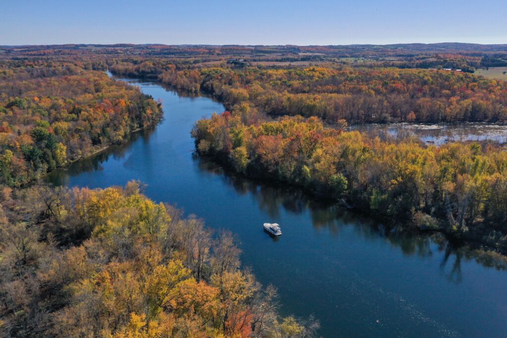 Aerial view of a river bending through autumn forest
