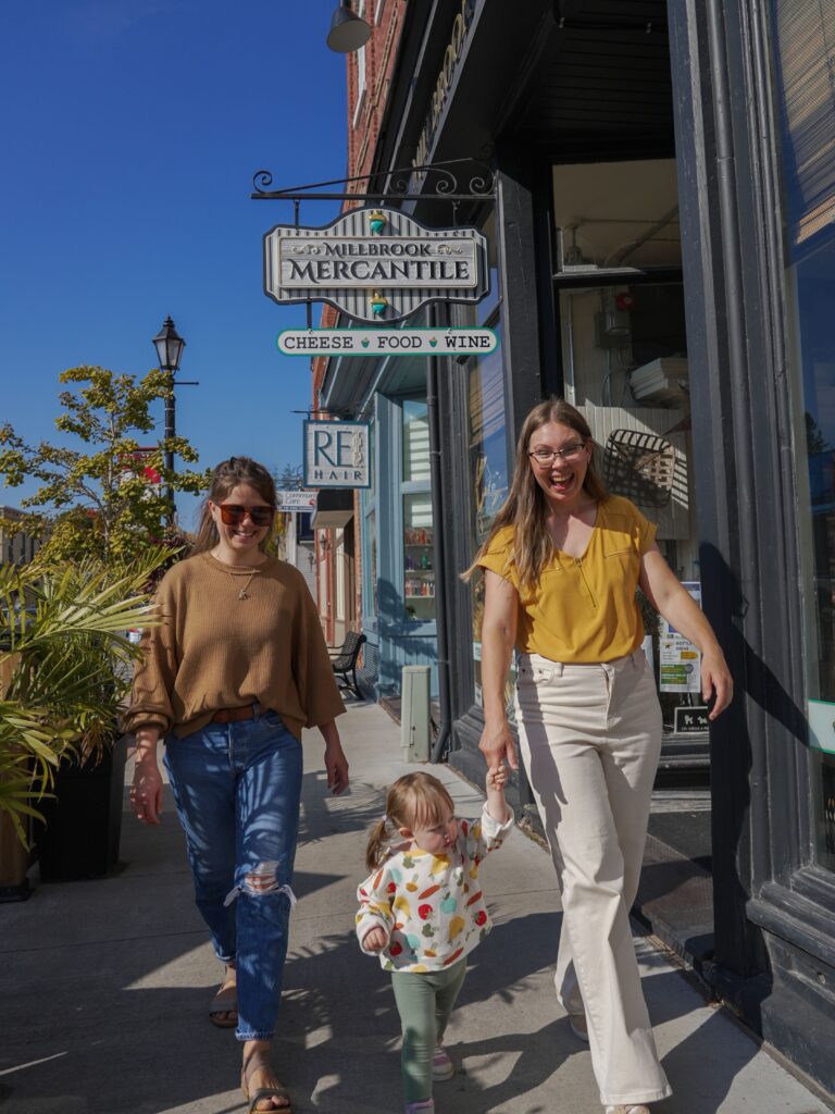 Friends walking a small-town main street on a sunny fall day
