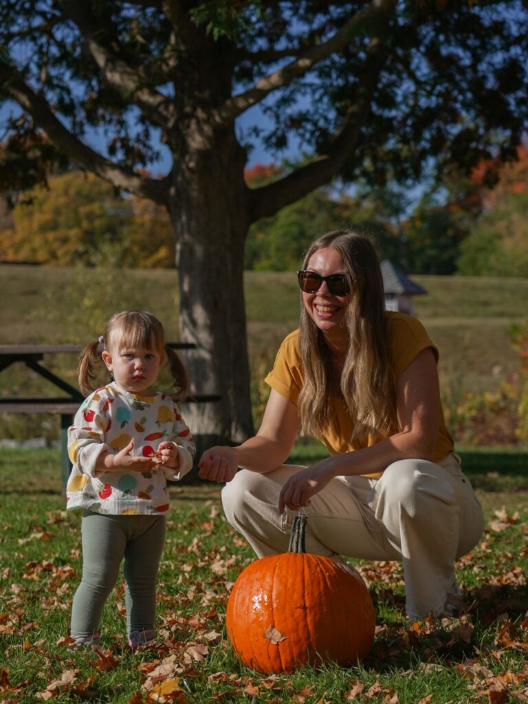 Mother and toddler with pumpkins on a farm in autumn