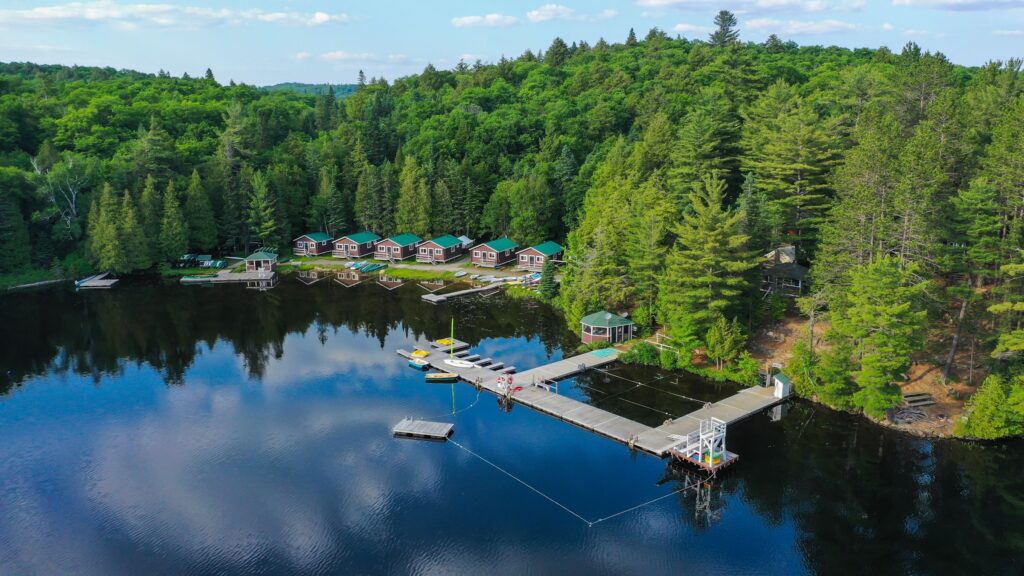 Aerial view of a lakeside resort and dock surrounded by forest