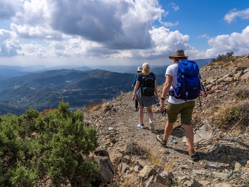 Two hikers on a rocky mountain trail above a valley