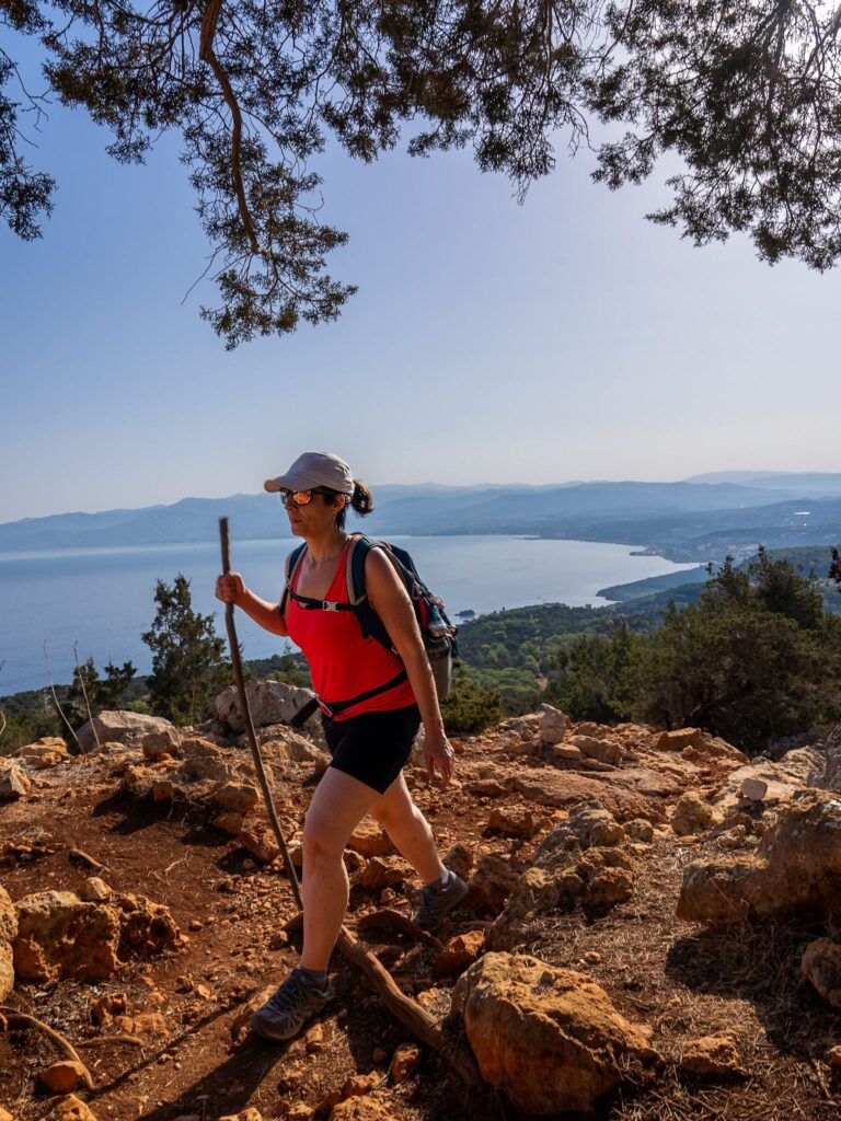 Hiker on a rocky trail above the sea and mountains