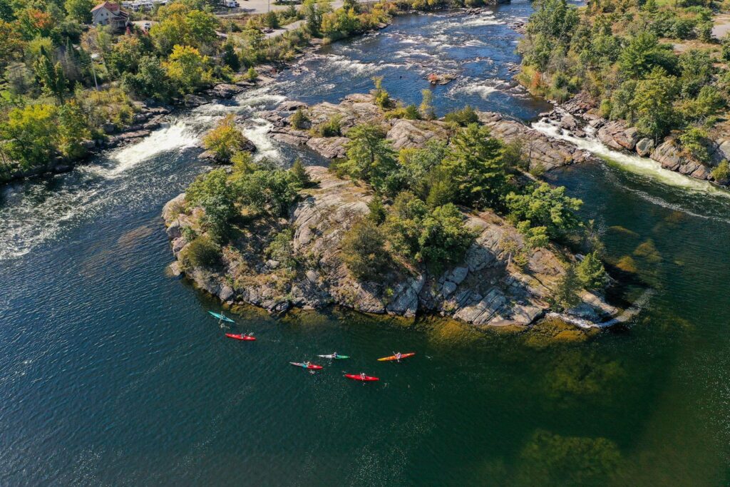 Aerial view of kayakers paddling around a rocky river island